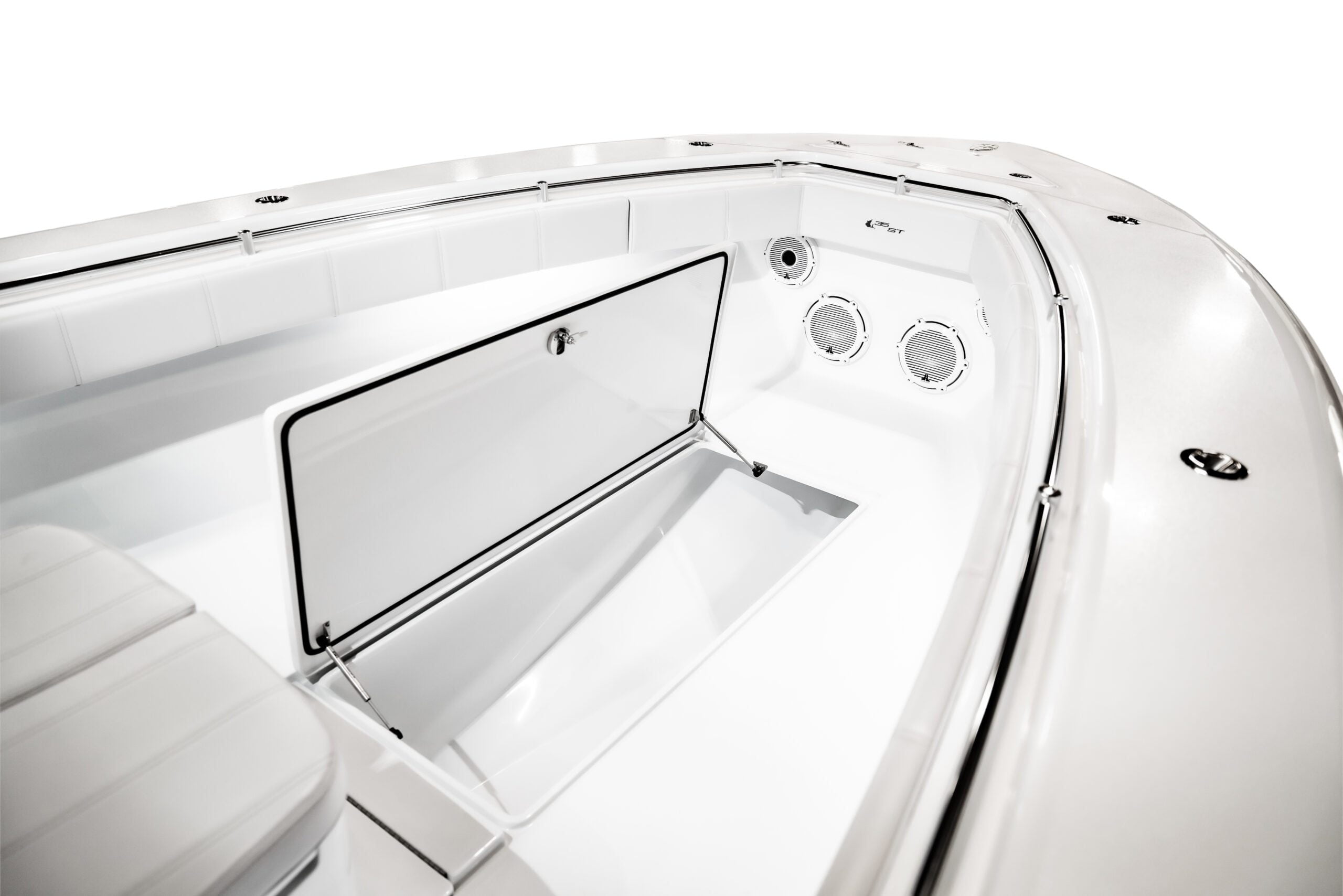 The image shows the interior of a boat, focusing on an open storage compartment and two round ventilation grills. The compartment door is raised, revealing an empty, clean storage area.