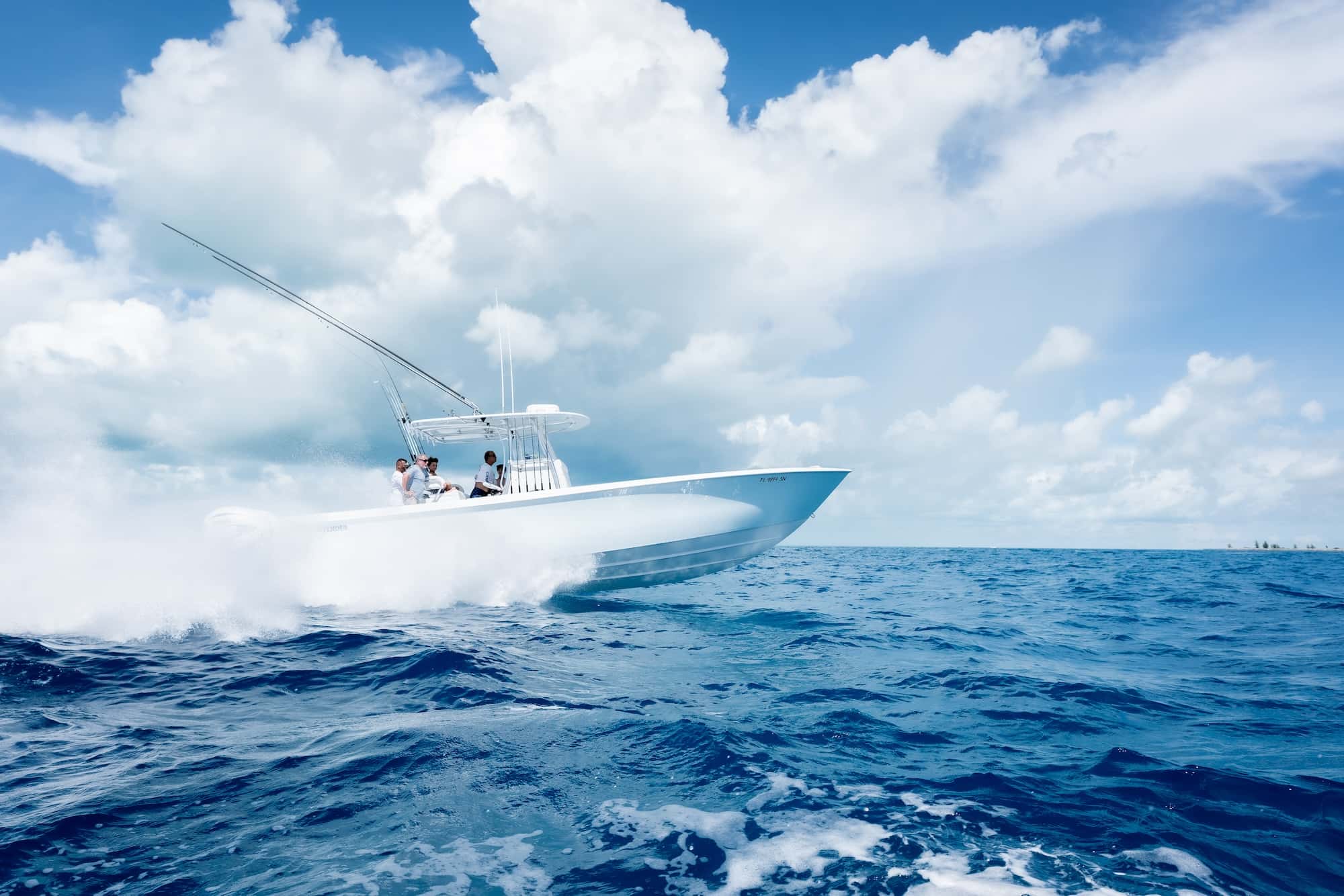 A motorboat with three passengers speeds across a blue ocean on a sunny day with scattered clouds.