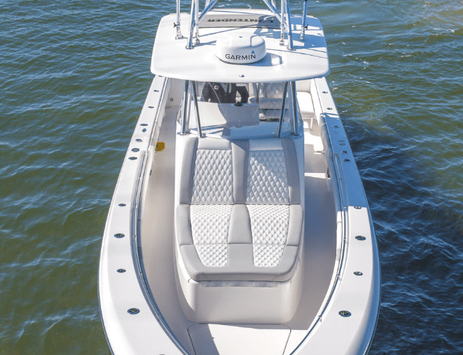 A white boat with a Garmin navigation system, featuring cushioned seating at the front, is shown in water from an overhead view.