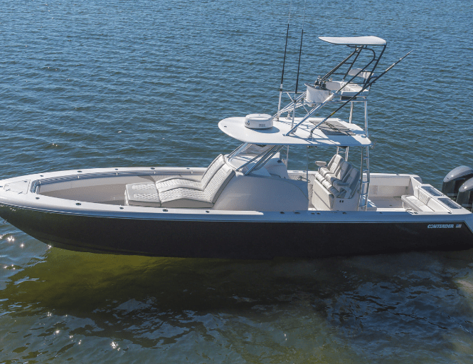 A motorboat with a dark hull and two outboard engines is floating on a body of water. The boat has a center console with seating and a raised observation deck with additional controls.