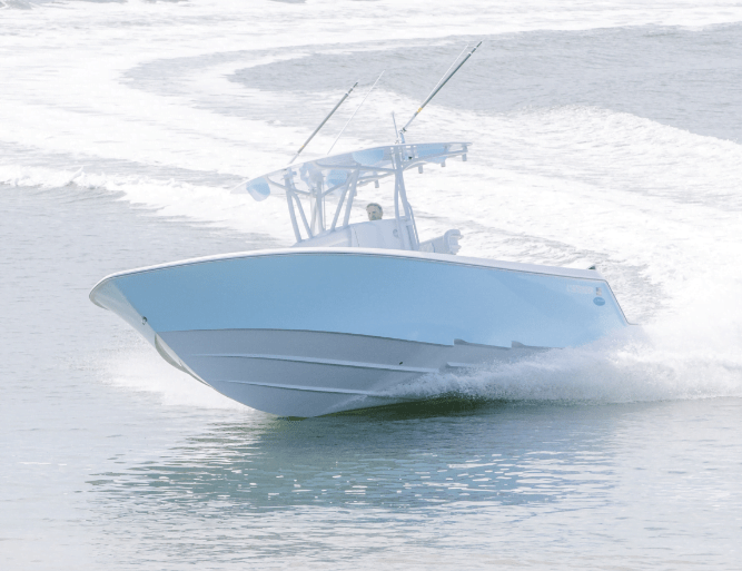 A blue motorboat with two fishing rods speeds across the water, leaving a wake behind it.