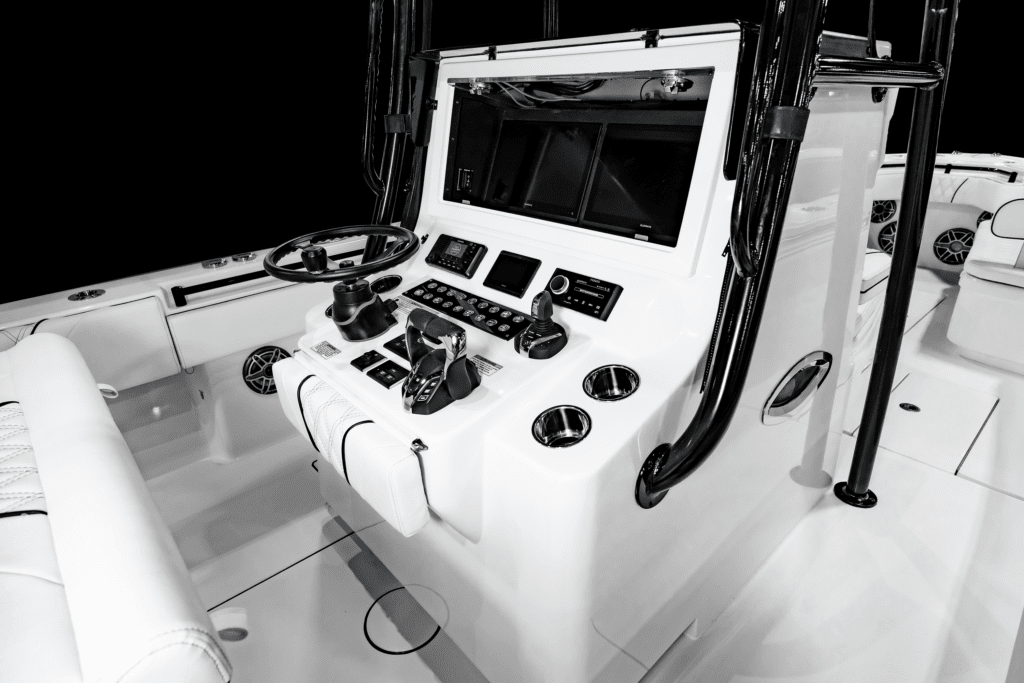 A modern boat cockpit with various controls, including a steering wheel, throttle, and multiple electronic displays, set against a clean, white interior.