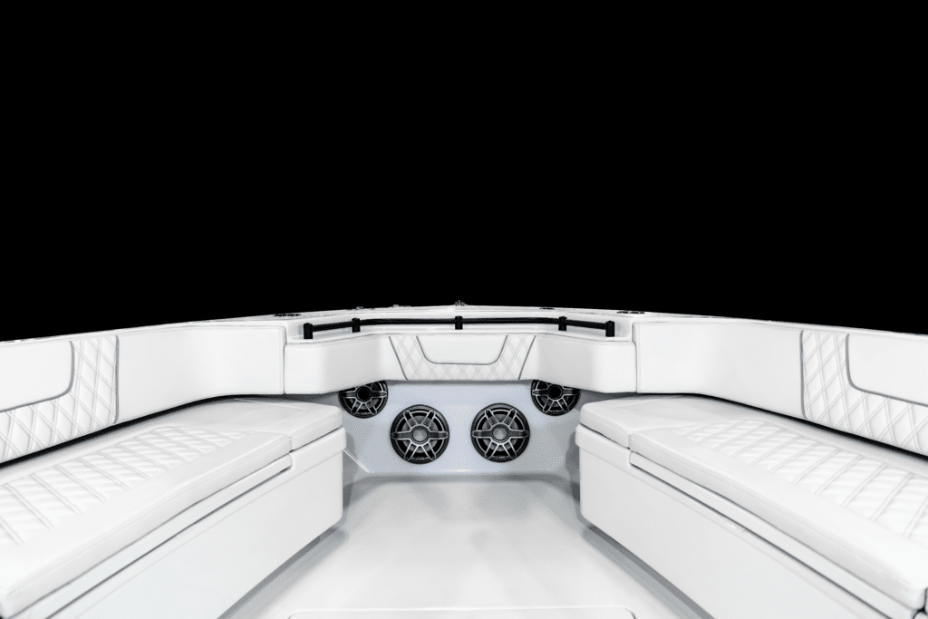 Front view of a boat's seating area with white cushioned seats and multiple built-in speakers against a black background.