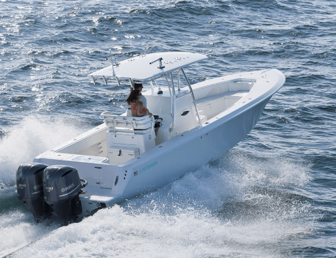 A person navigates a white motorboat with two outboard engines through choppy waters.