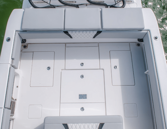 Aerial view of the deck area of a boat, featuring multiple storage compartments with closed lids and cushioned seating around the perimeter.