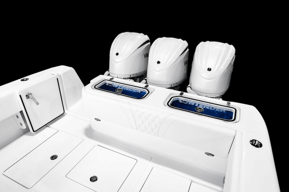 A view of the stern of a boat featuring three outboard engines and compartments with blue interiors on a black background.